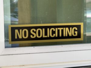 Pictured, a sign on my window of hieroglyphs indecipherable to a door-to-door salesperson.